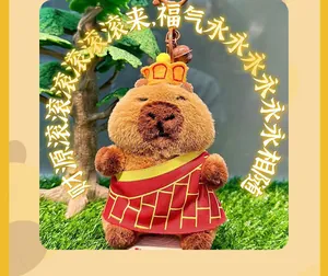 Close-up of cute plush capybara keychain wearing crown and monk robe with a bell