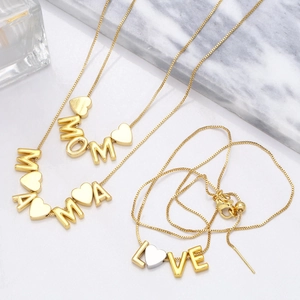 Detailed view of three gold-plated necklaces with MOM MAMA and LOVE heart letter pendants