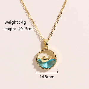 Detail view of gold whale pendant with blue crystal wave and precise size measurements