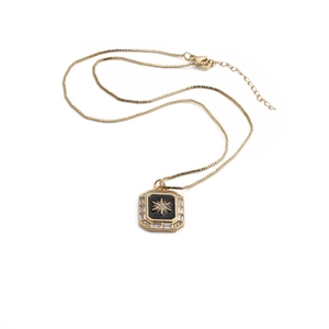 Détail du pendentif étoile dorée avec émail noir et bordure en zircone brillant