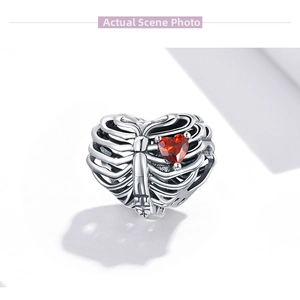 Close-up of S925 silver hollow heart charm with a sparkling red zircon center stone