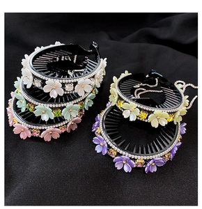 Detail of five colorful rhinestone flower hair clips for elegant ponytails and buns