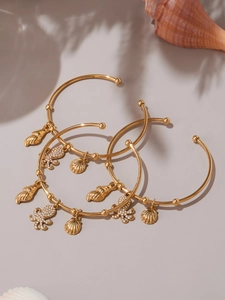Detailed shot of golden marine charms including a shell, scallop and crystal octopus charm