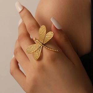 Adjustable golden stainless steel ring featuring a dragonfly design on a model finger