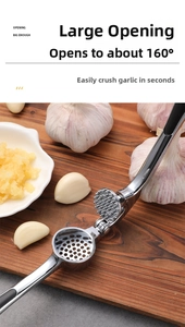 Manual stainless steel garlic press with 160 degree opening shown on wooden board
