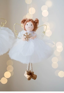 Detail of plush Christmas angel with white mesh skirt and golden snowflake accessory