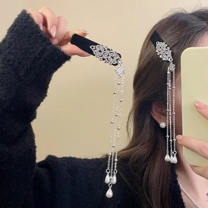 Detail of silver tassel hair clip with hollow patterns and white teardrop pearls