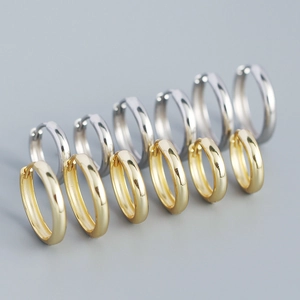 Close-up of minimalist gold and silver geometric hoop earrings with polished metal finish