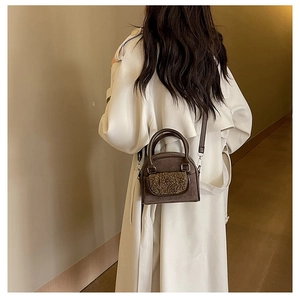 Brown vintage plush crossbody bag detail showing faux suede and faux fur texture on white coat