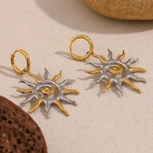 Vue macro détaillée de boucles d'oreilles soleil avec finition bicolore or et argent