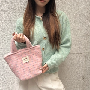 Detail of pink felt tote bag featuring colorful fiber specks and a white brand label