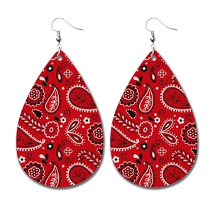 Detail of red teardrop PU leather earrings with white and black paisley pattern texture