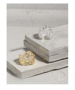 Makroaufnahme von S925 Ringen in Gold und Silber mit Kristall und Lavatextur