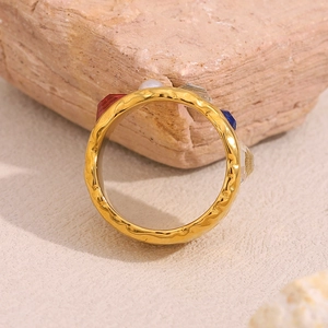 Detail of vintage 18K gold plated ring with multicolored zircons on textured stone
