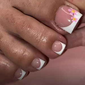 Close-up of pink press-on toenails with white French tips and delicate flower accents