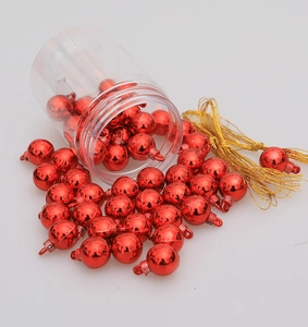 Dettaglio di mini palline di Natale rosse da 1,5 cm con cordoncini d'oro e tubo trasparente