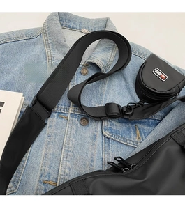 Détail de la bandoulière réglable et du petit porte-monnaie sur le sac de sport noir