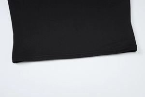 Gros plan sur le tissu en maille noire montrant l'ourlet à double surpiqûre et la finition