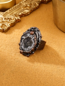 Macro shot of handcrafted bronze-tone ring featuring a natural grey geode druzy stone