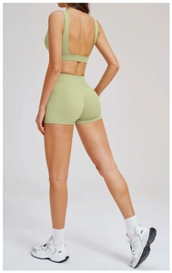 Dettaglio del set yoga verde chiaro con reggiseno sportivo incrociato e pantaloncini a vita alta