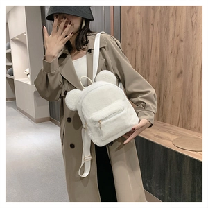 Close-up of fluffy white plush backpack with cute 3D bear ears on a female model