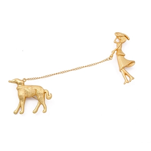 Baroque style gold brooch featuring a lady with greyhound linked by a delicate chain