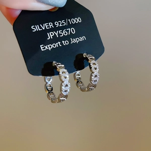 Vista macro di orecchino in argento 925 con zirconi scintillanti e design a maglia CD