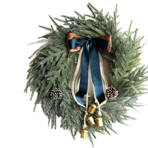 Artificial Christmas wreath with green needles, blue ribbon, pine cones and gold bells
