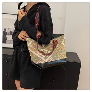 Ethnic tote bag with geometric patterns and leather bottom detail shown on a model