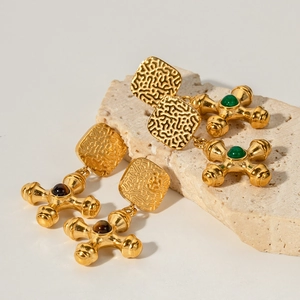 Detail of 18k gold stainless steel cross earrings with inlaid green and brown tiger eye stone