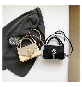 Détail de sacs à bandoulière carrés en beige et noir avec boucle en métal brillant