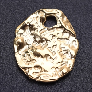 Macro detail of irregular gold oval 304 stainless steel pendant with lava hammer texture