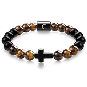 Close-up of tiger eye beaded bracelet with cross charm and letter C pendant on white base