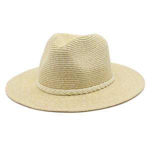 Détail d'un chapeau Panama en paille beige avec un ruban décoratif tressé blanc autour de la calotte