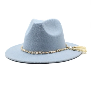 Detail of light blue wool fedora hat featuring gold chain, pearls and beige tassel fringe