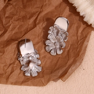 Detailed close-up of silver daisy flower cluster stud earrings with metal texture