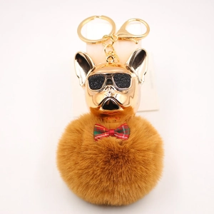Dettaglio portachiavi bulldog con occhiali da sole, pompon marrone e fibbia in oro