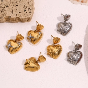 Vista detallada de pendientes de corazón y estrella con textura de lava en oro y plata