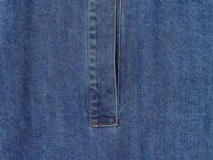 Vue macro du tissu denim bleu montrant les coutures doubles détaillées et le tissage sergé