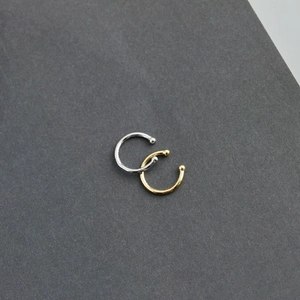 Detail view of gold and silver minimalist C-shaped ear cuffs with small ball ends
