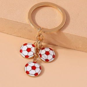 Detail of red and white enamel soccer charms on a golden metal keychain link