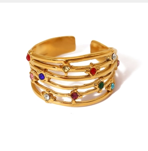 Detail of multi-layer gold ring featuring colorful gemstones and an adjustable open design