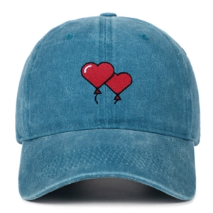Detail of red heart embroidery on washed cotton baseball cap with vintage finish