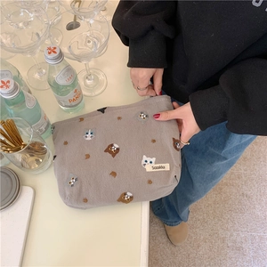 Detailed view of gray cotton makeup bag with cute cat embroidery held by hand