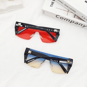 Détail de lunettes de soleil oversize avec strass, rivets et monture en résine chic