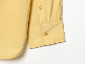 Detail of yellow poplin shirt showing double-button cuffs and precise stitching details