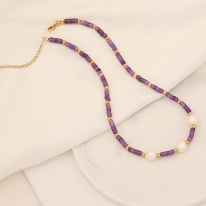 Détail du collier fait main avec pierres naturelles violettes, perles blanches et perles d'or