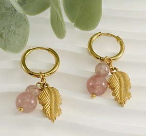 Detail of gold leaf charms and pink natural stones on stainless steel earrings