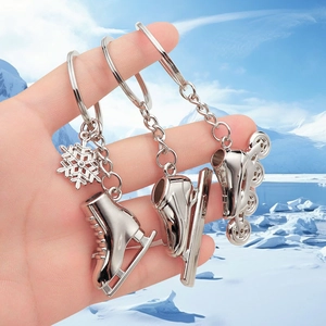 Custom metal roller skate keychain with snowflake charm held against a glacier backdrop