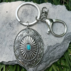 Western style turquoise keychain with embossed silver cactus flower pendant on grey stone